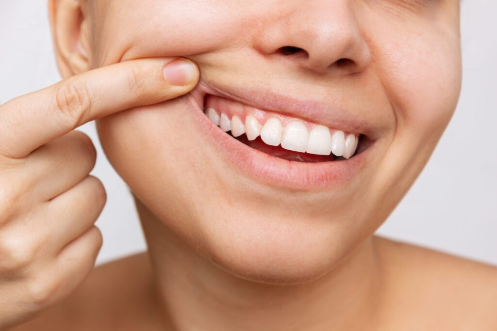 Depiction of an adult woman smiling, showing off her healthy teeth and gums.